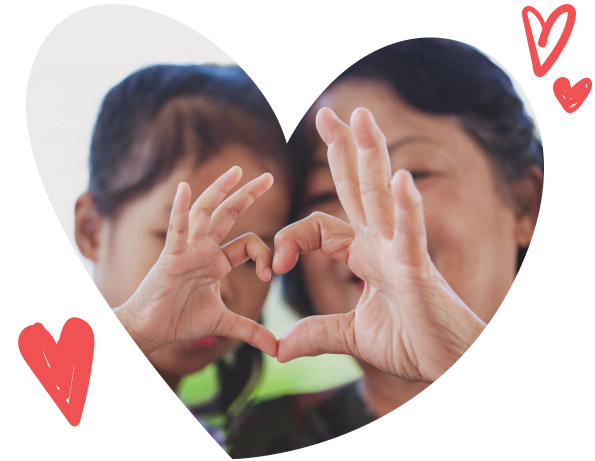 A parent and child making a heart symbol with their hands